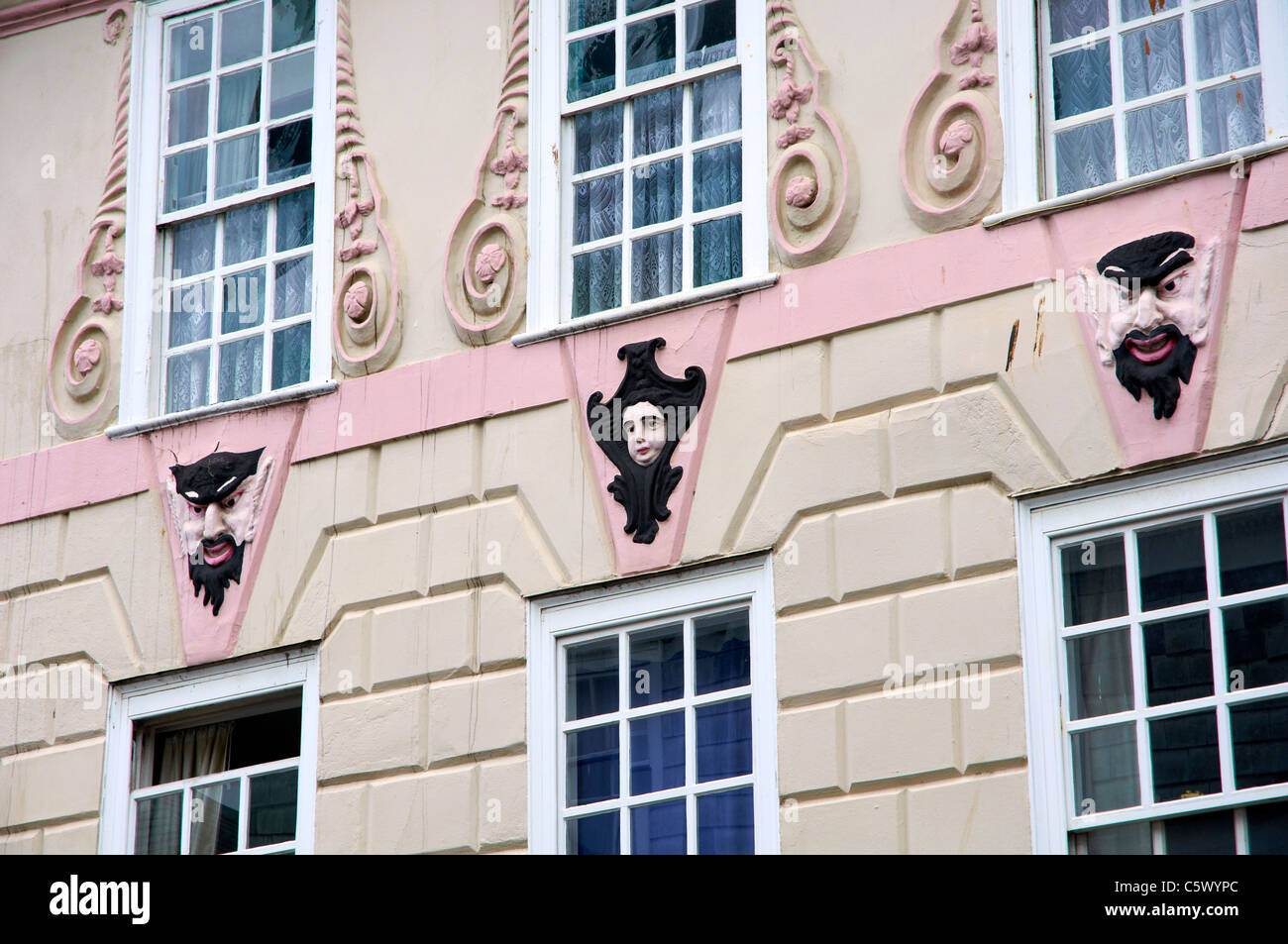 Edificio georgiano en Totnes, Devon, Inglaterra con elaborada decoración y estilo Máscara teatral pintado de caras. Foto de stock