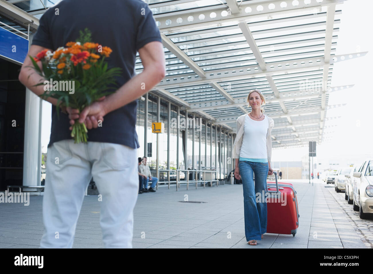 Alemania, Leipzig-Halle, Aeropuerto, Mujer con maleta, Hombre sujetando las  flores Fotografía de stock - Alamy