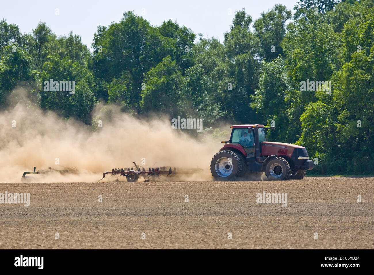 Tractor en seco y polvoriento campo agrícola Foto de stock