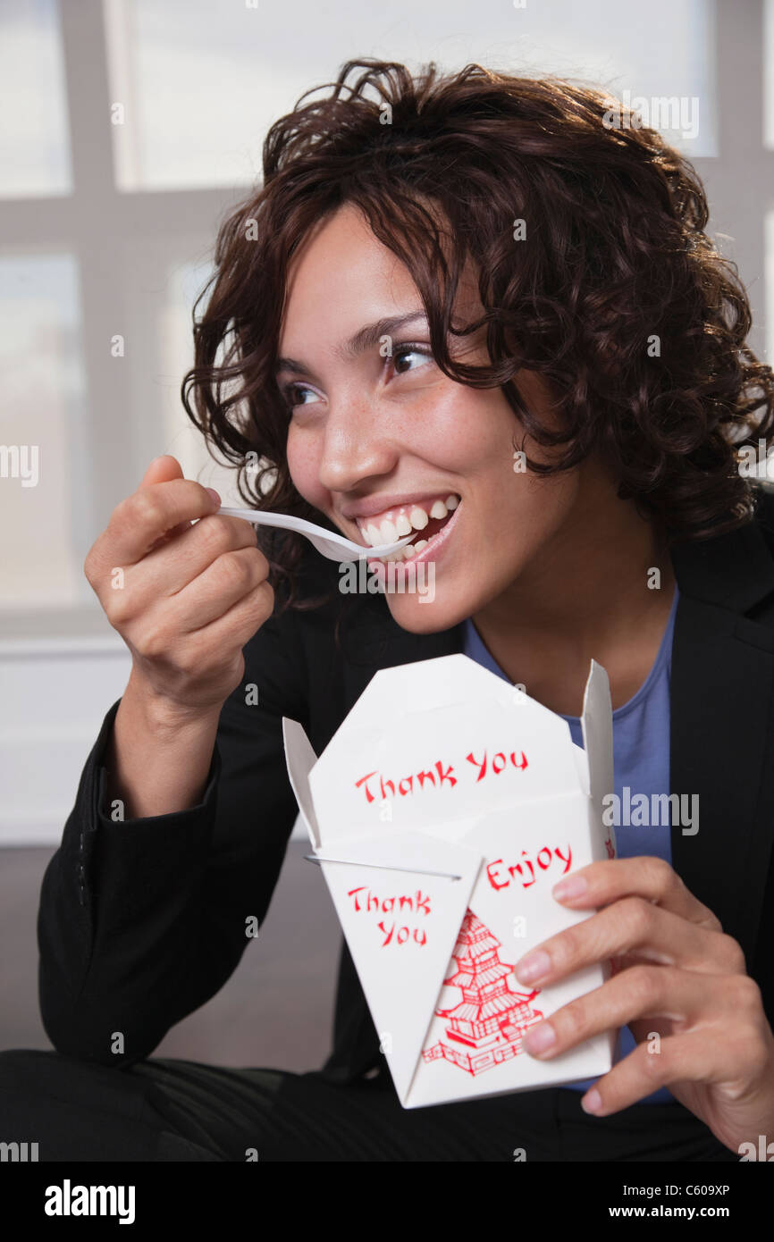 Los Estados Unidos, Nueva York, Ciudad de Nueva York, mujer sonriente comiendo alimentos Chinise Foto de stock