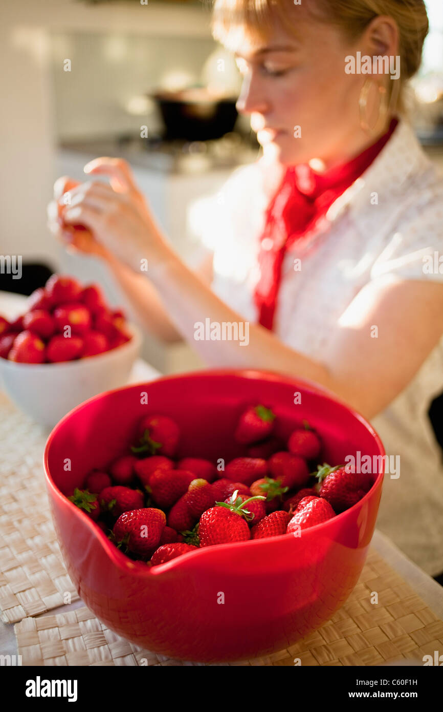 Mujer Mondar las fresas en la cocina Fotografía de stock - Alamy