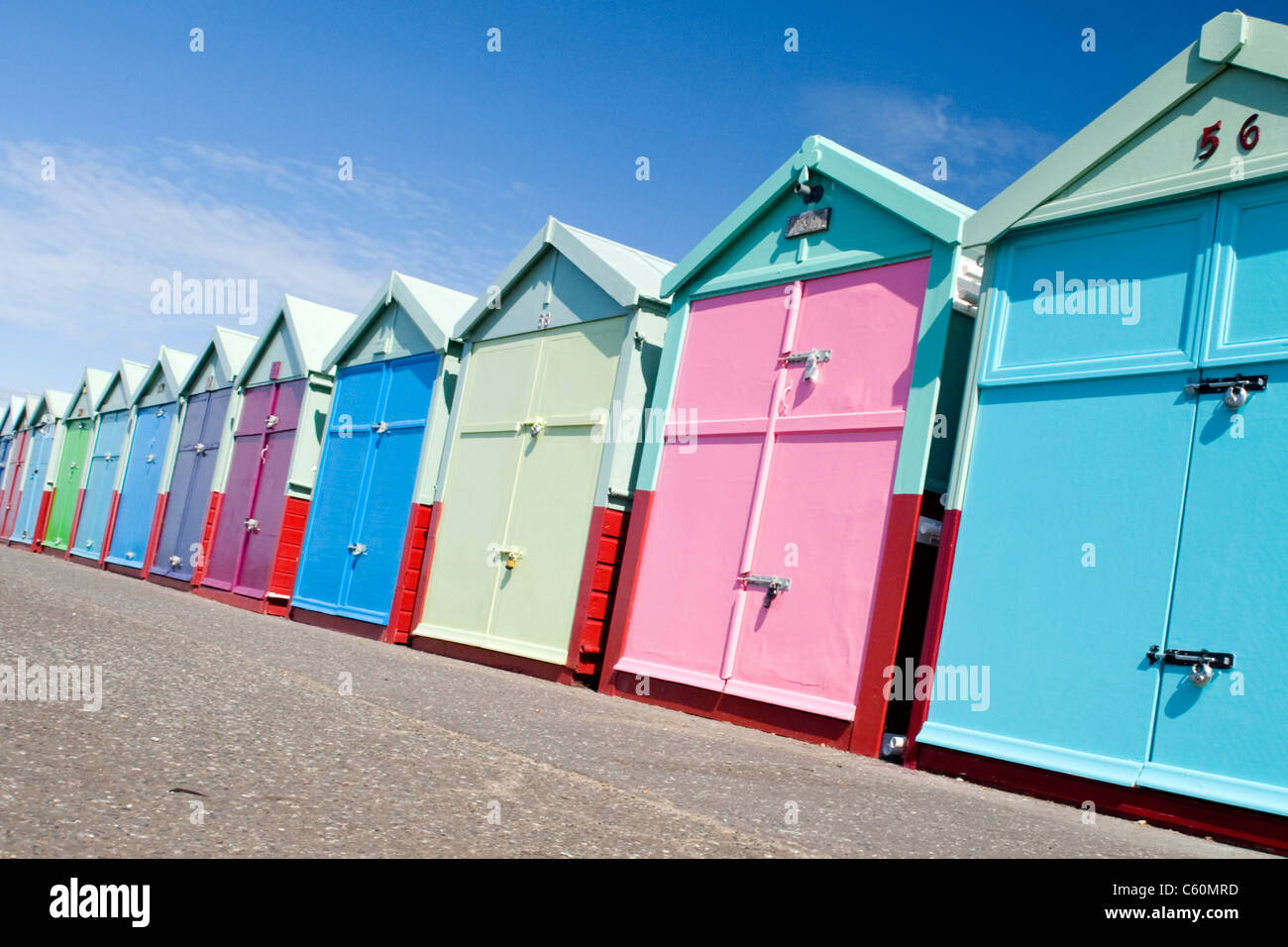 East Sussex , Hove , realmente coloridos y coloridas casetas de playa en el paseo marítimo o paseo Foto de stock