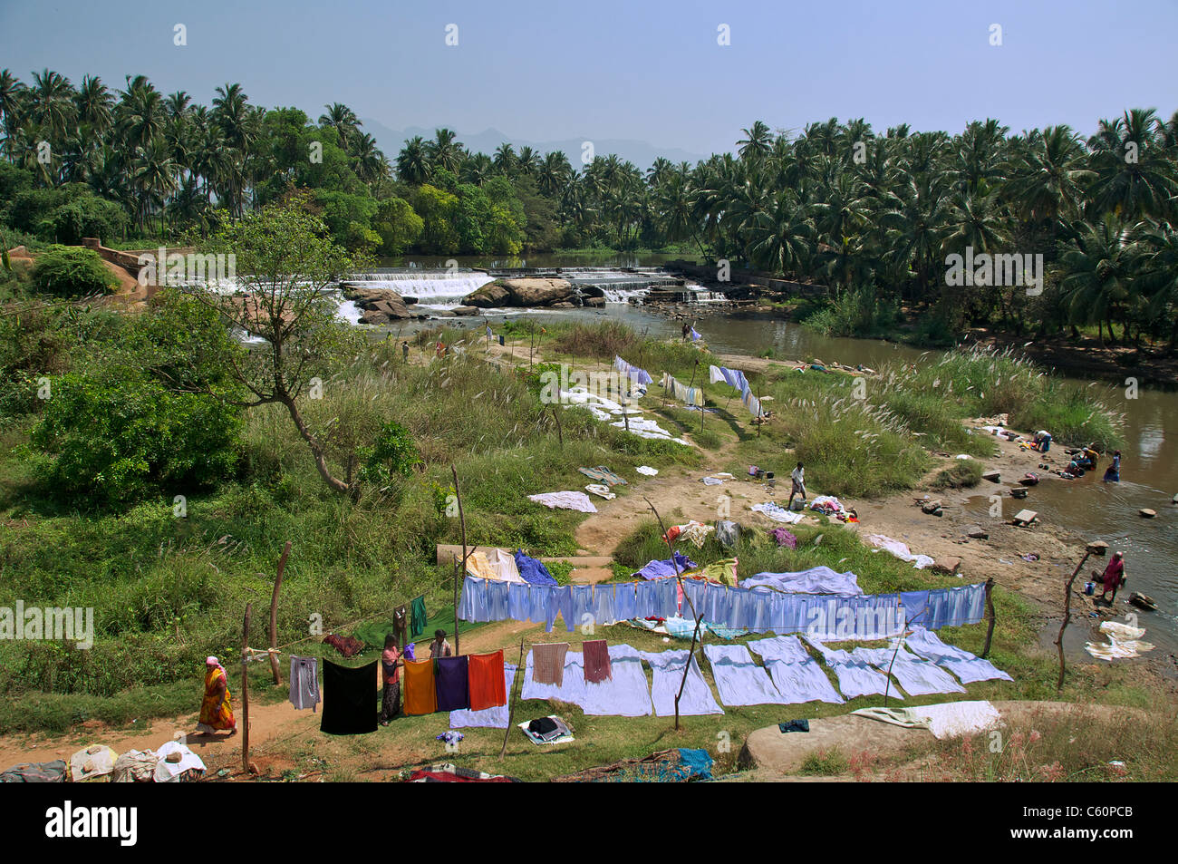 Lavado y secado de ropa en el banco del río de Tamil Nadu, en el sur de la India Foto de stock