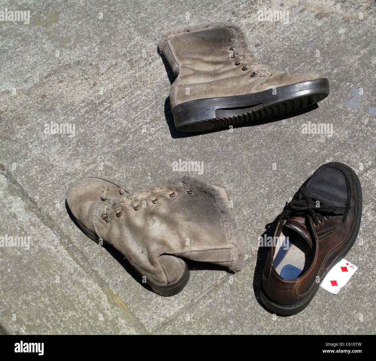 Tres zapatos abandonados en la acera con cuatro de diamantes juegos de  cartas Fotografía de stock - Alamy