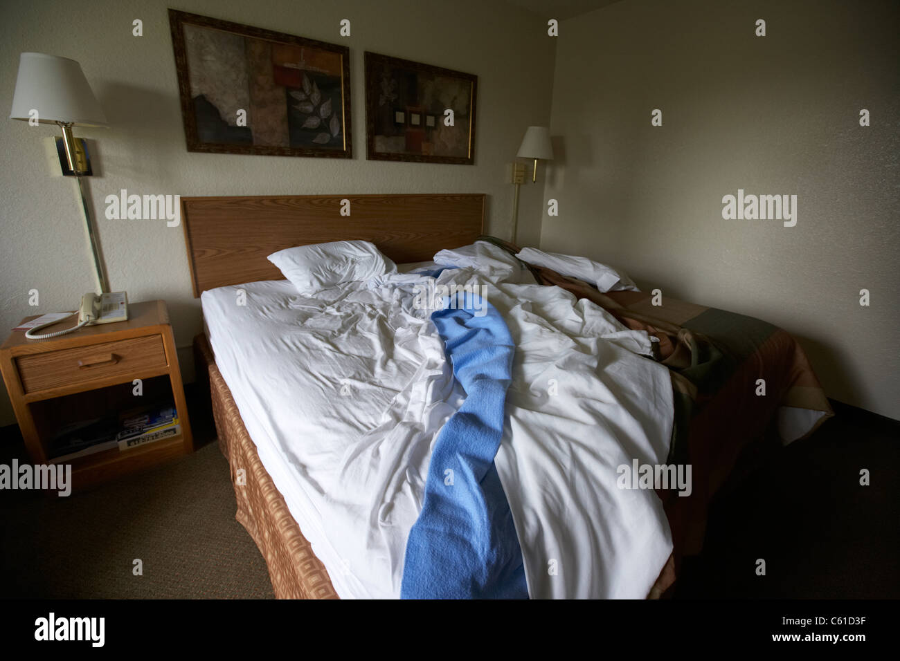 Desordenado durmió en una cama doble en la habitación de motel hotel barato en los EE.UU. Foto de stock