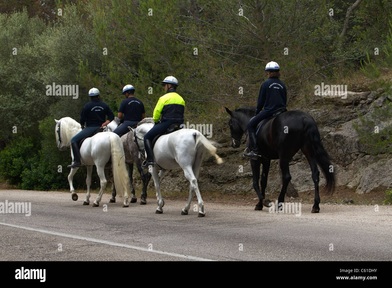 Una patrulla de la policía montada en la carretera que conduce a un castillo en Palma de Mallorca. Foto de stock