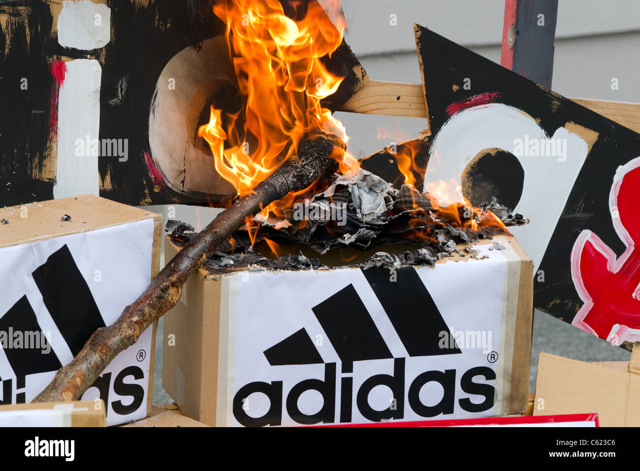 Los manifestantes prendieron fuego a burlarse del Logotipo de Adidas y  cajas para protestar contra los precios de Adidas todo negro camisas de  rugby Fotografía de stock - Alamy