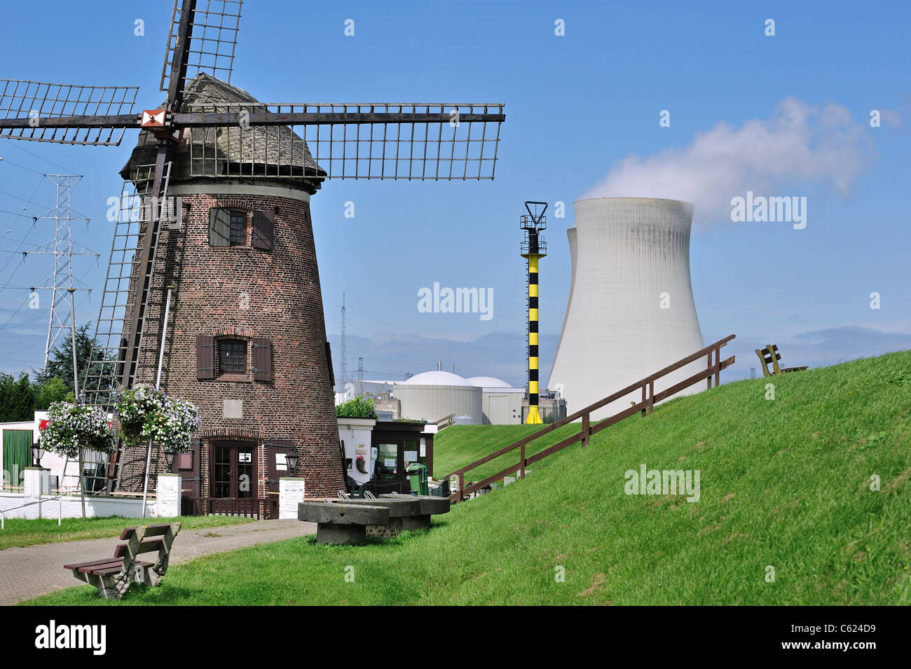 El Windmill Scheldedijkmolen y torres de enfriamiento de la planta nuclear Doel junto al río Escalda en Beveren, Bélgica Foto de stock