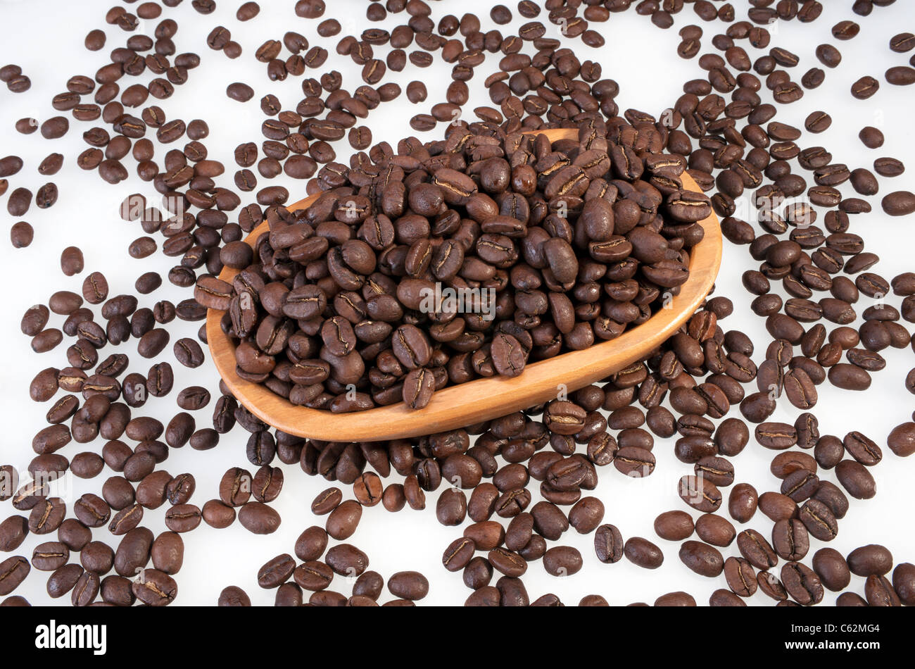 Los granos de café tostado en el tazón de madera Foto de stock