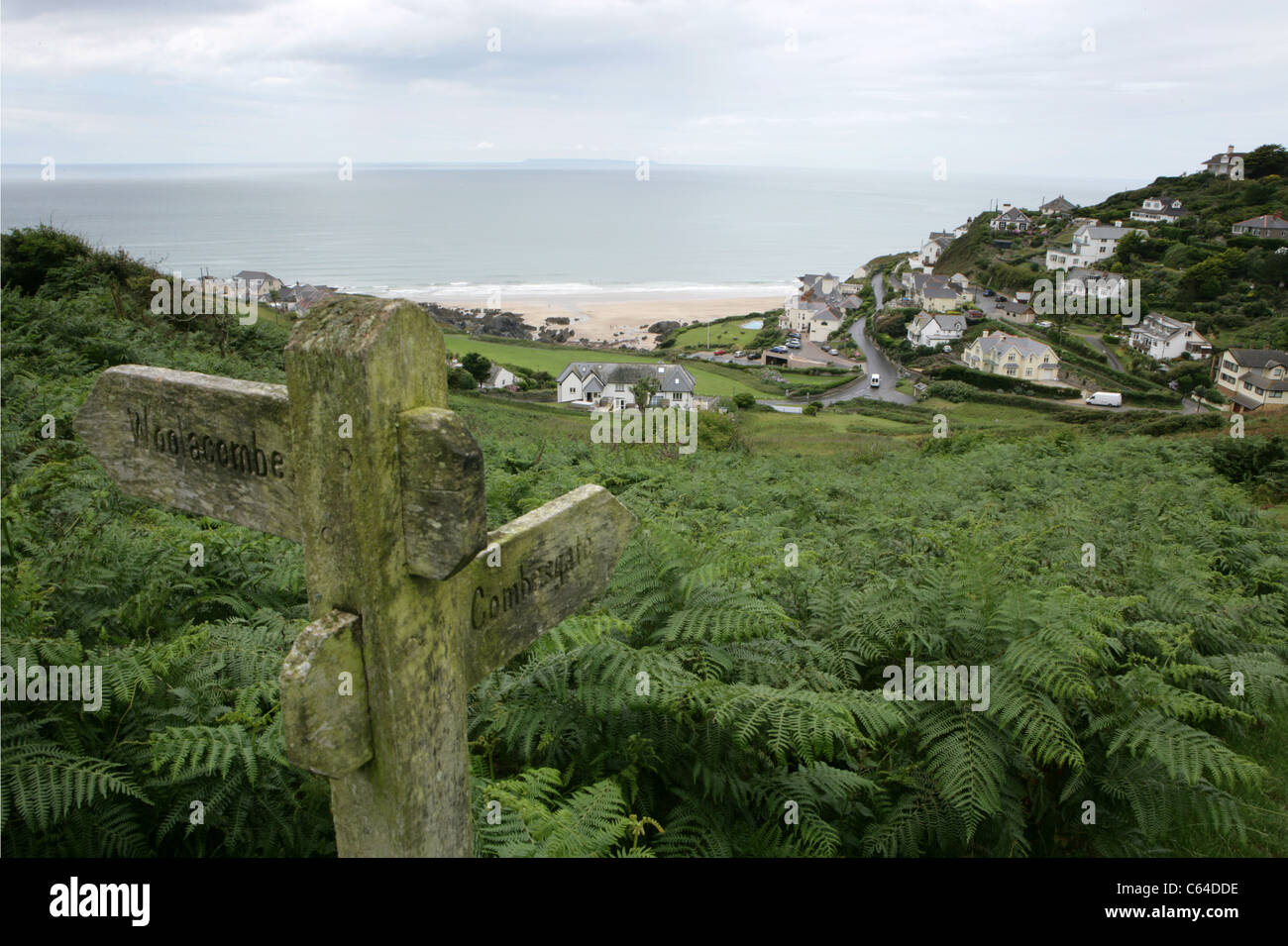 Ubicación: La señal de dirección indica Woolacombe y Combesgate con vistas a la playa de Mortehoe en North Devon. Un destino popular de vacaciones en West Country. Foto de stock