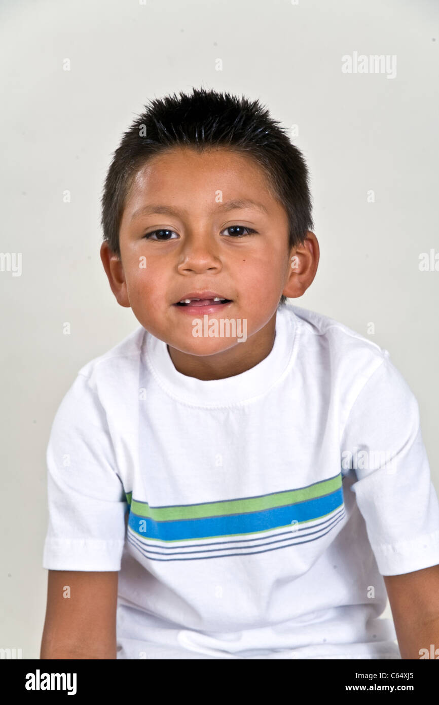 Los jóvenes 6-7 años niño hispano con sonrisa desdentada que faltan dos dientes frontales. pensativo soñando sentado señor © Myrleen Pearson Foto de stock