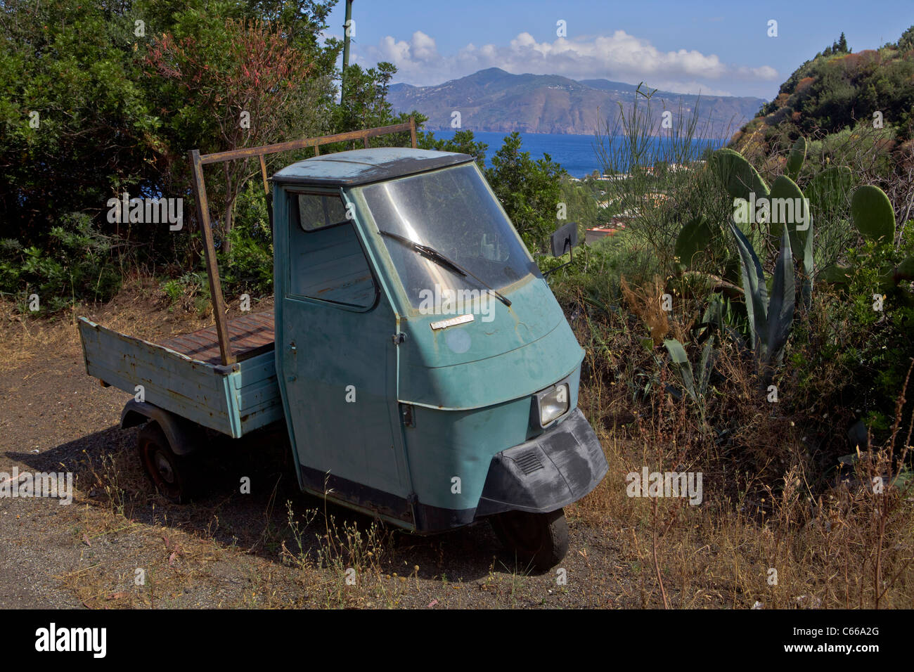 Vintage verde tres ruedas ciclomotor Vespa estacionada en algún lugar de Sicilia - costa mediterránea, Italia, Europa. Foto de stock