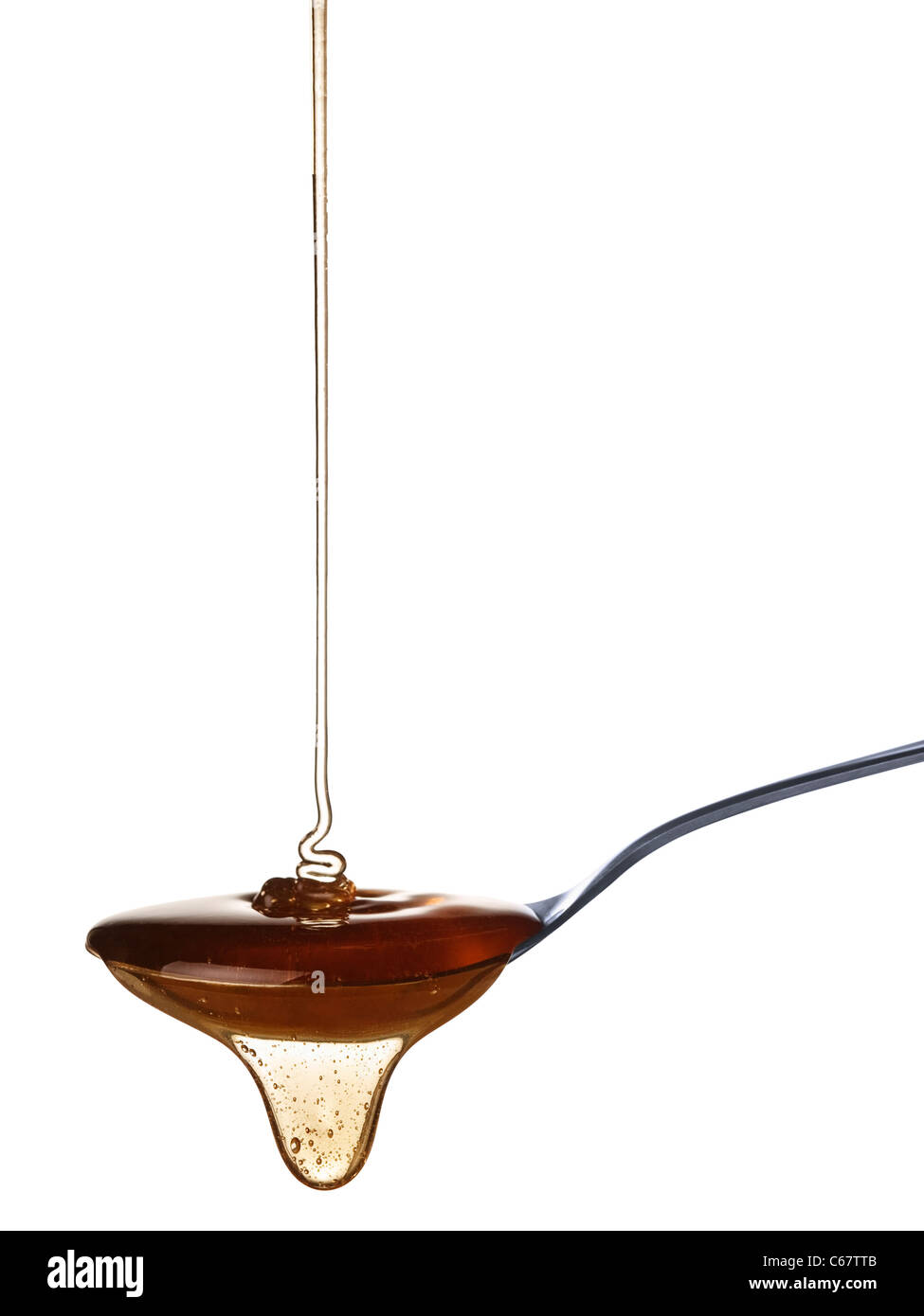 La miel lentamente cae en la cuchara. Foto de stock