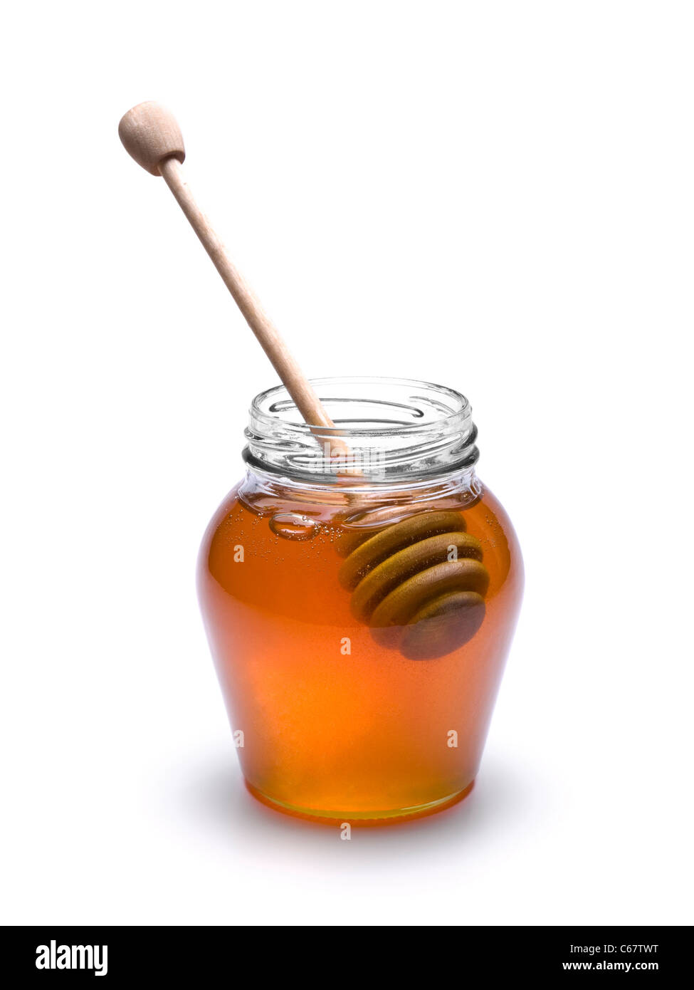 Tarro de miel con un drizzler madera interior. Aislado sobre fondo blanco. Foto de stock