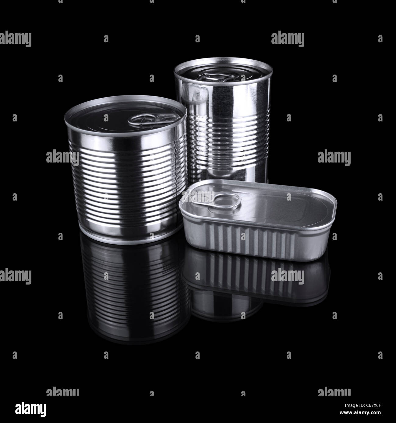 Tres diferentes latas aislado sobre un fondo negro. Foto de stock