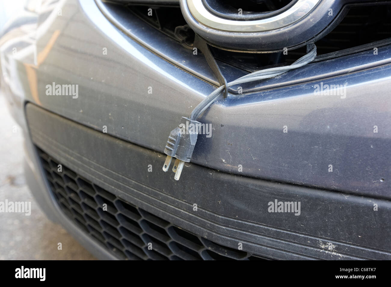 El cordón del calentador del bloque de motor y enchufe colgando de un coche para el frío invierno Saskatoon, Saskatchewan, Canadá Foto de stock