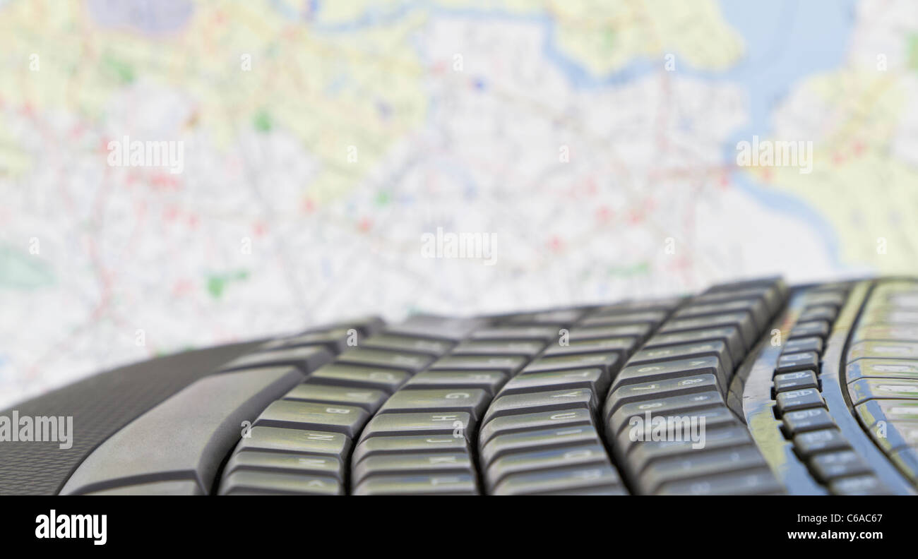 Teclado negro colocado delante del mapa con el enfoque selectivo en el teclado con poca profundidad de enfoque utilizado. Foto de stock