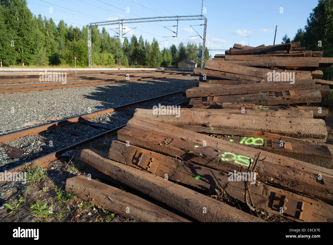 Pila de viejos traviesas de madera del ferrocarril fuera de servicio esperando el transporte, Finlandia Foto de stock