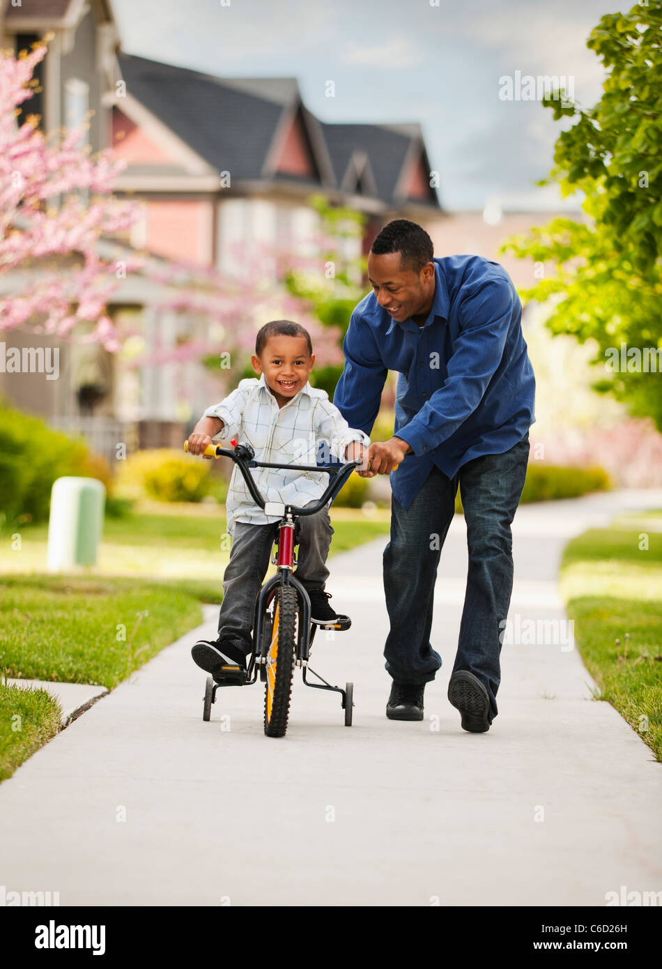 Padre enseñar al hijo a andar en bicicleta Foto de stock