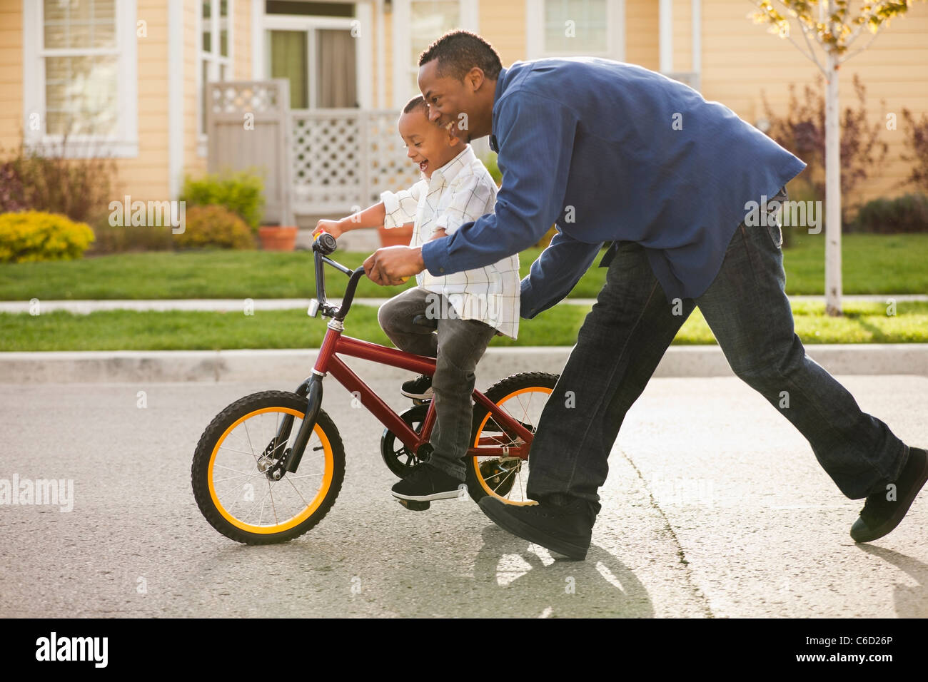 Padre enseñar al hijo a andar en bicicleta Foto de stock