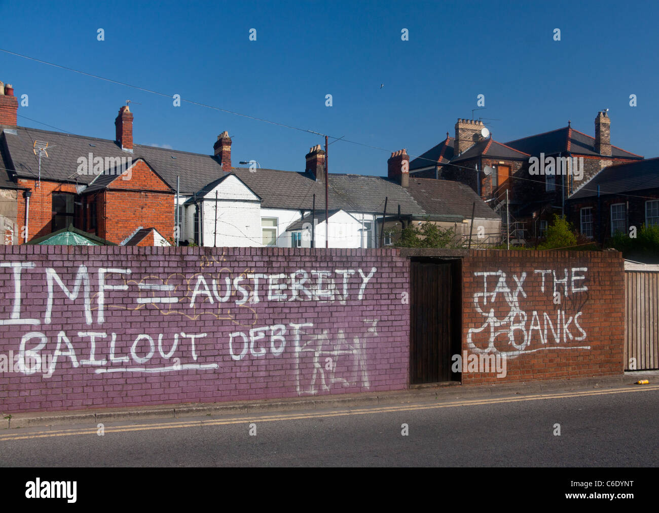 Graffiti políticos condenando la política económica del FMI Rescate de austeridad fiscal = Deuda los bancos pintura blanca sobre la pared de ladrillo rojo Foto de stock