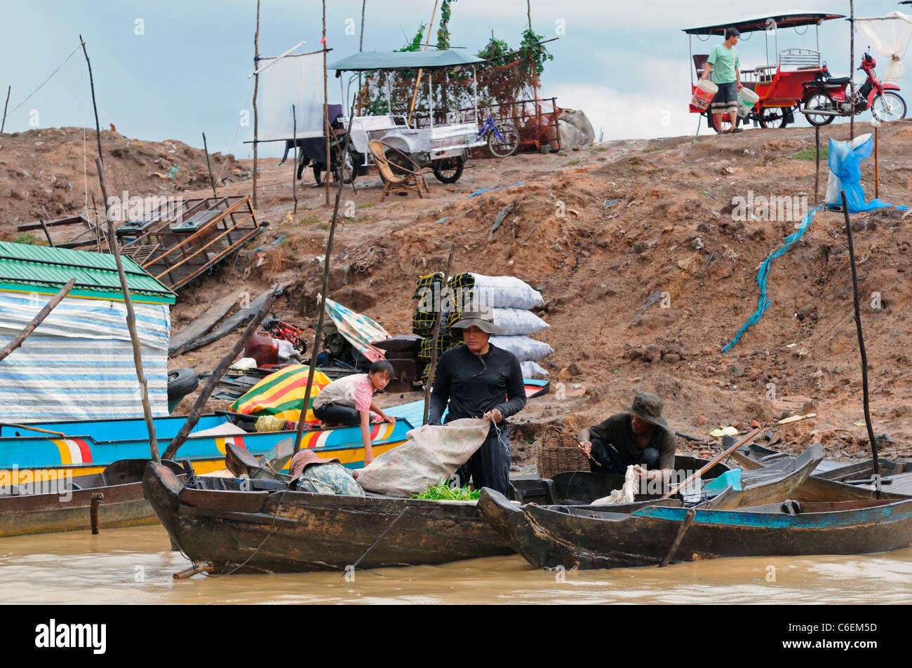 Lago de agua dulce Tonlé Sap Siem Reap, Camboya familia gente cargando sacos de carga transporte transporte barco Foto de stock