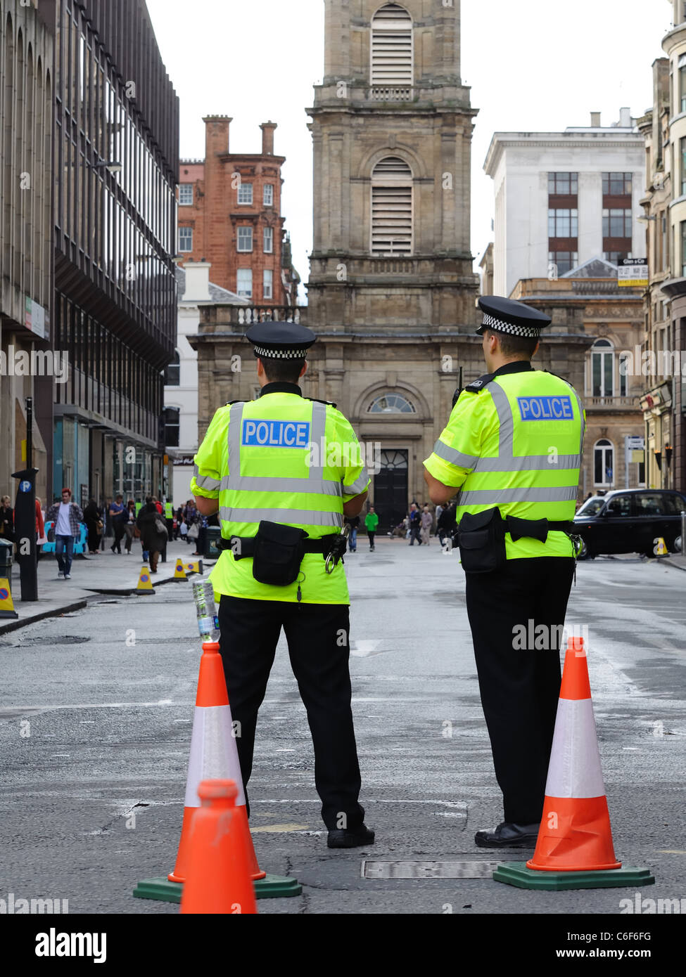Dos policías escoceses realizando funciones de control del tráfico en una calle del centro de la ciudad de Glasgow. Foto de stock