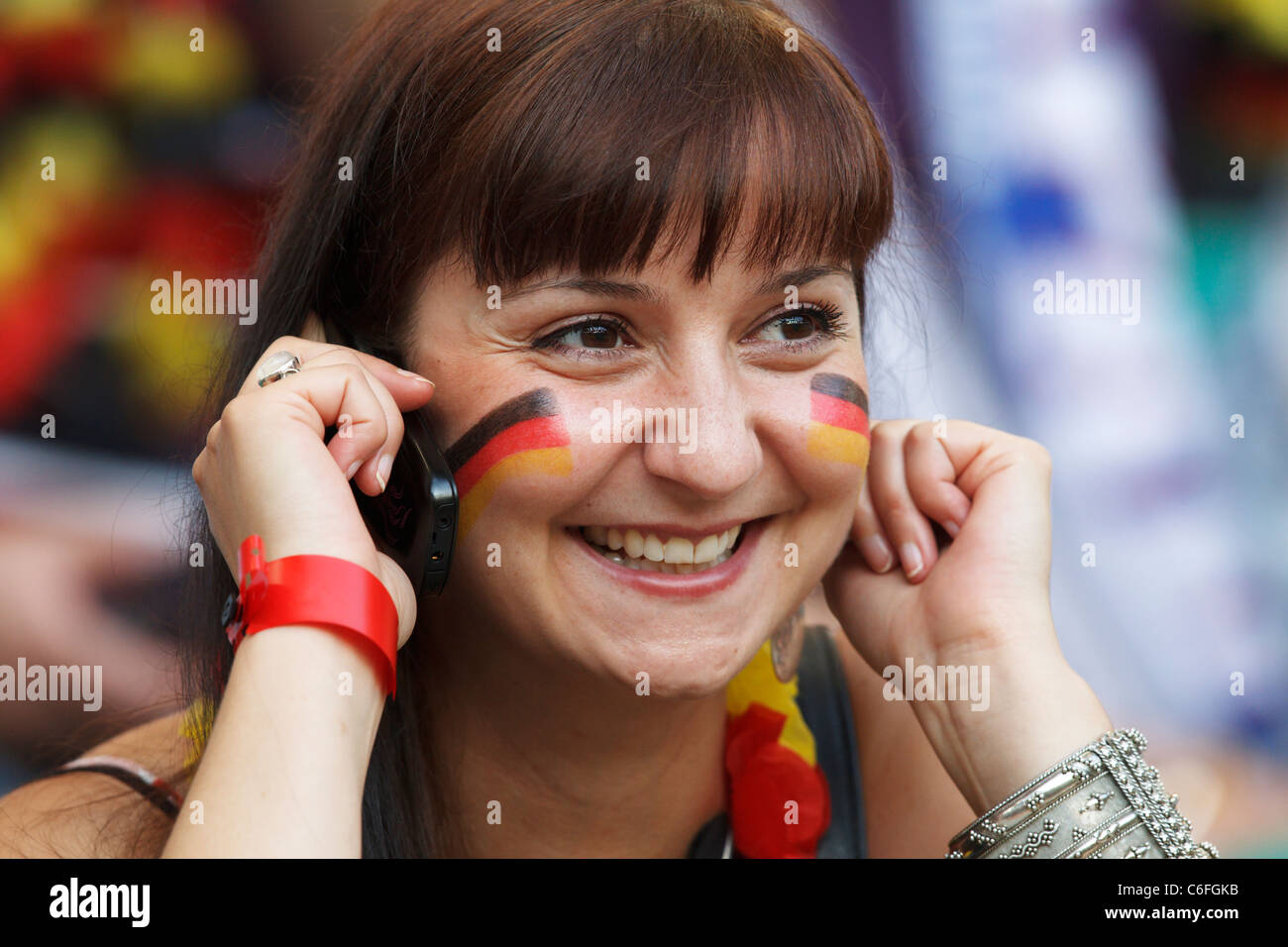 Alemania partidario sonríe mientras habla por su teléfono móvil a la Copa Mundial Femenina 2011 quarterfinal partido entre Alemania y Japón. Foto de stock