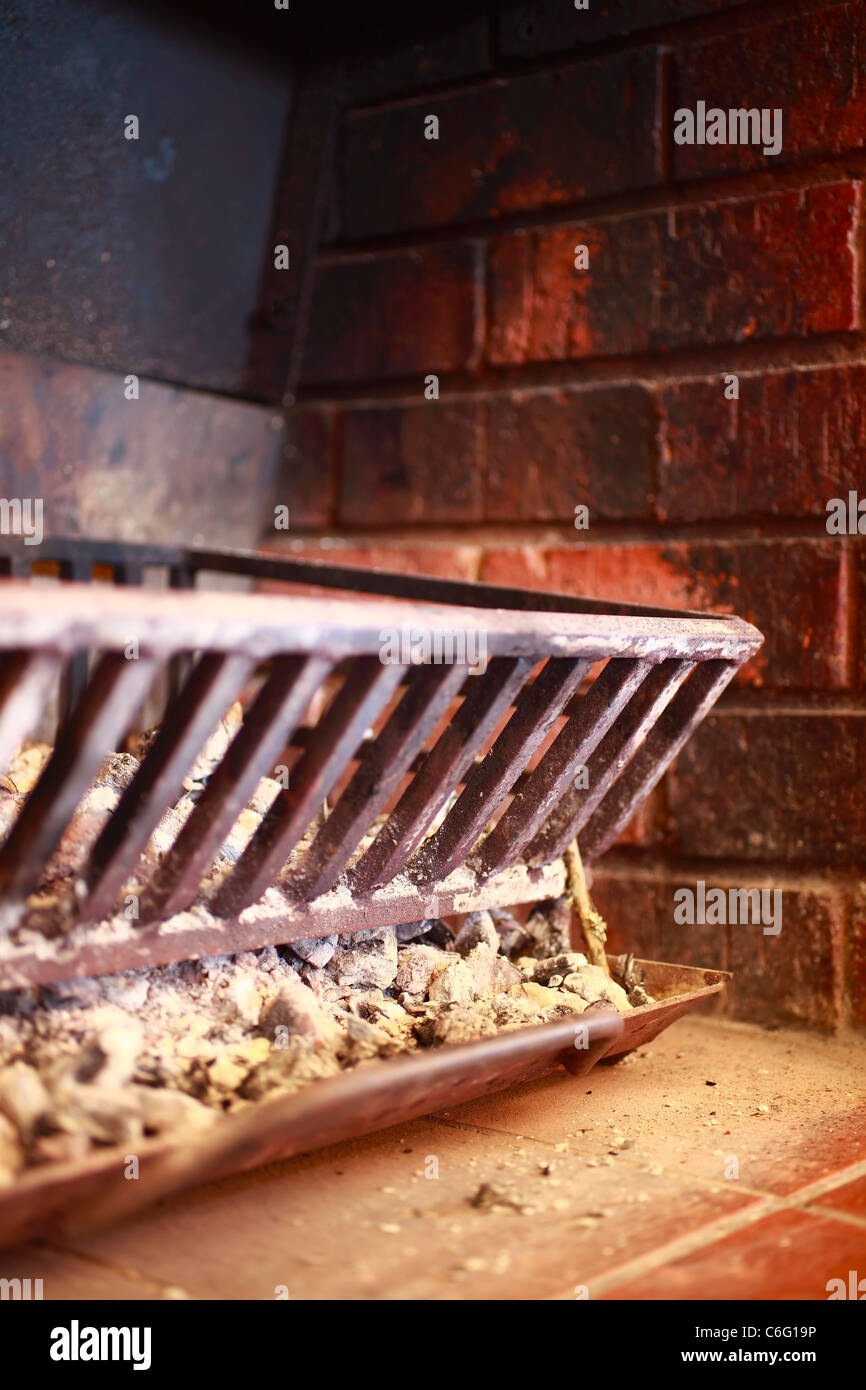 Chimenea. Una reja de hierro fundido y bandeja de carbón en un fogón de ladrillo. Foto de stock