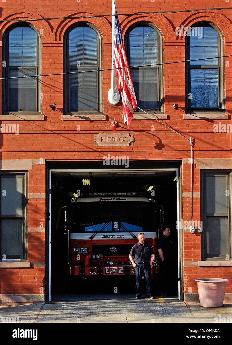 Casa de Bomberos de la ciudad de Jersey con la bandera americana y bombero Foto de stock