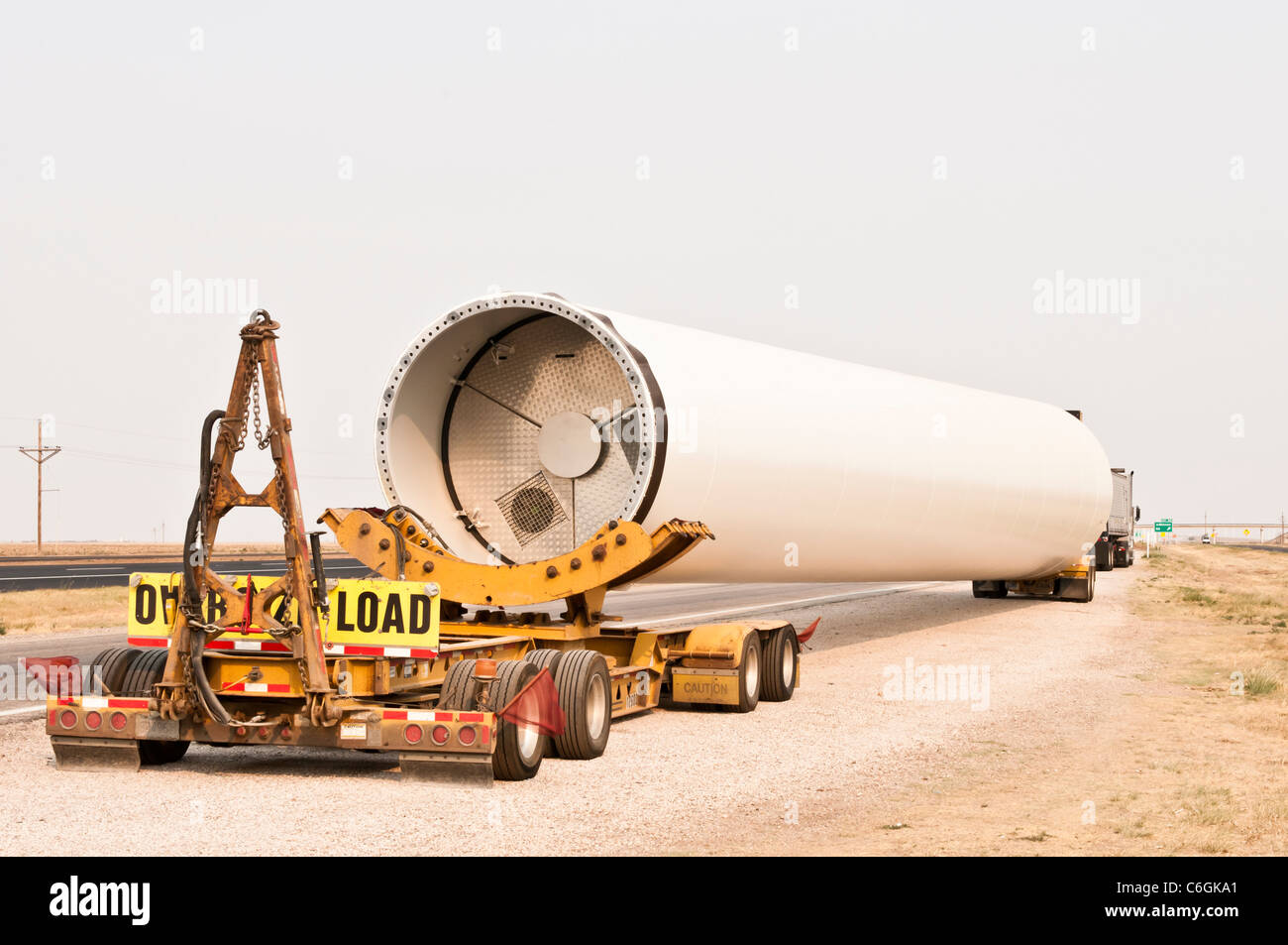 Una sección de la torre de un aerogenerador de eje horizontal se entrega a un sitio en construcción cerca de Amarillo, Texas. Foto de stock