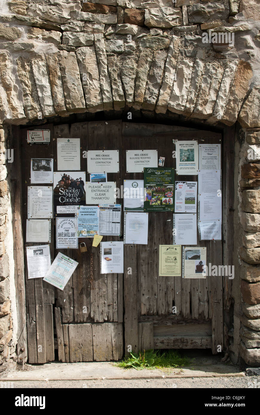 Avisos de aldea anclado a las puertas de granero, Dent, Dentdale, North Yorkshire, Inglaterra. Foto de stock
