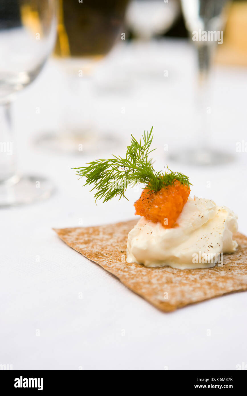 Crujiente pan cubierto con crema agria, huevas de salmón y eneldo Foto de stock