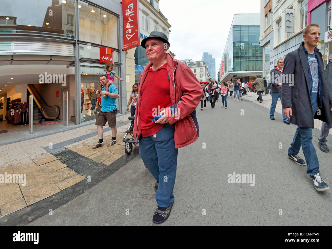 Bruselas, Bélgica. Hombre en rojo caminando por la calle principal de compras Foto de stock