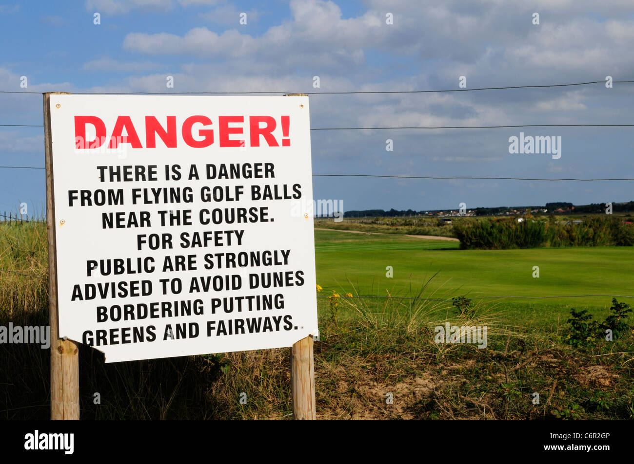 Peligro de volar las bolas de golf señal de advertencia, el Club de Golf Royal Norfolk occidental, Brancaster, Norfolk, Inglaterra, Reino Unido Foto de stock