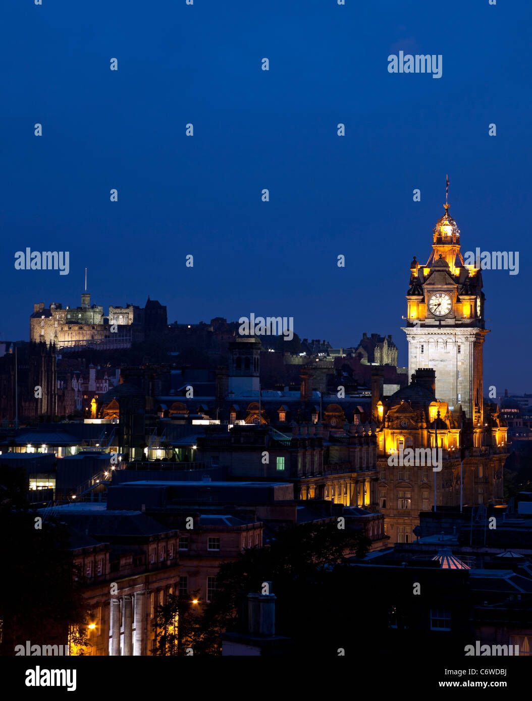 El Edinburgh city centre skyline iluminado al anochecer con el Hotel Balmoral y el castillo Foto de stock