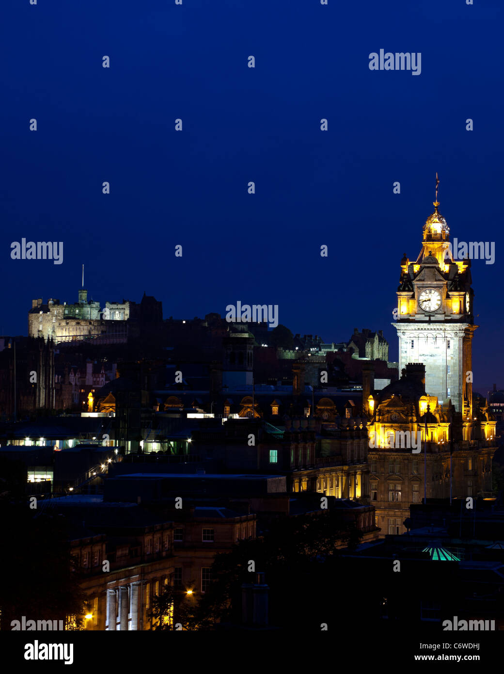 El Edinburgh city centre skyline iluminado al anochecer con el Hotel Balmoral y el castillo Foto de stock