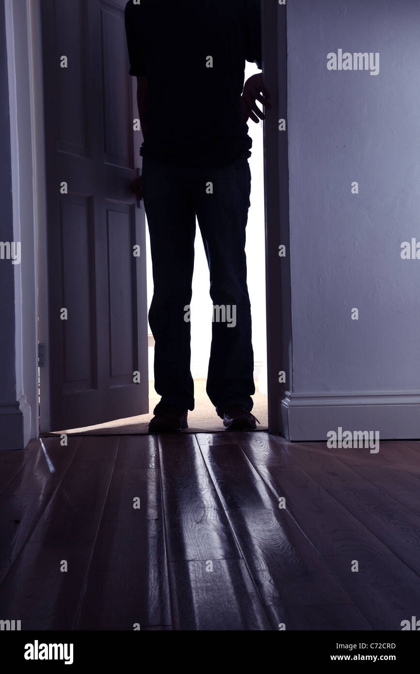Figura masculina de entrar en un cuarto oscuro. Foto de stock