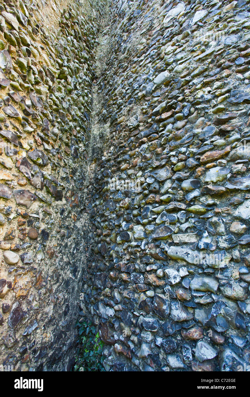 El muro de piedra de las ruinas de la iglesia de Santa María de Kirby Bedon en el punto donde se une la torre. Foto de stock