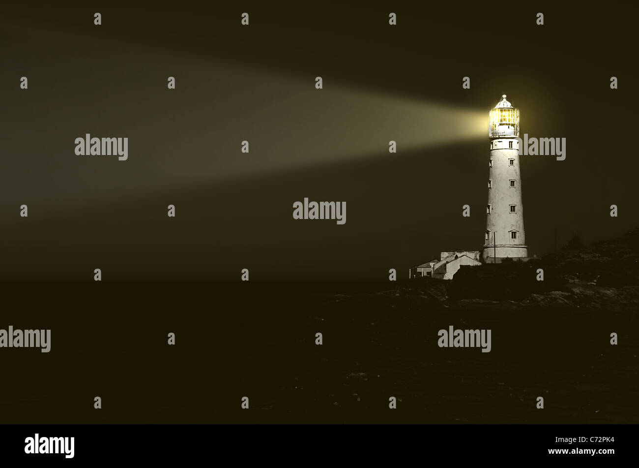 Faro en la noche: haz de luz sobre el mar Foto de stock