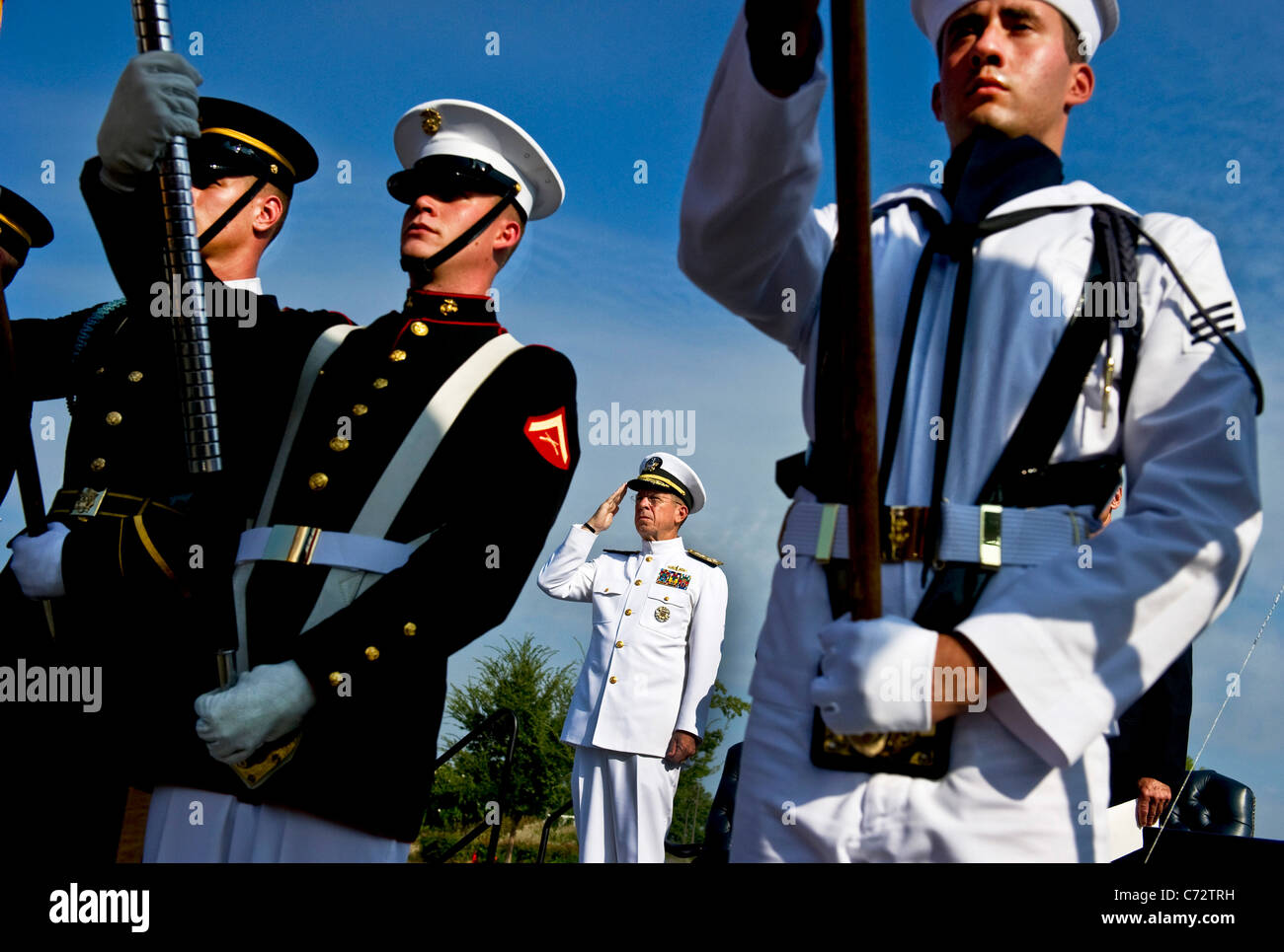 Marina de EE.UU. Adm. Mike Mullen, presidente de la Junta de jefes de personal rinde honores durante la reproducción del himno nacional. Foto de stock