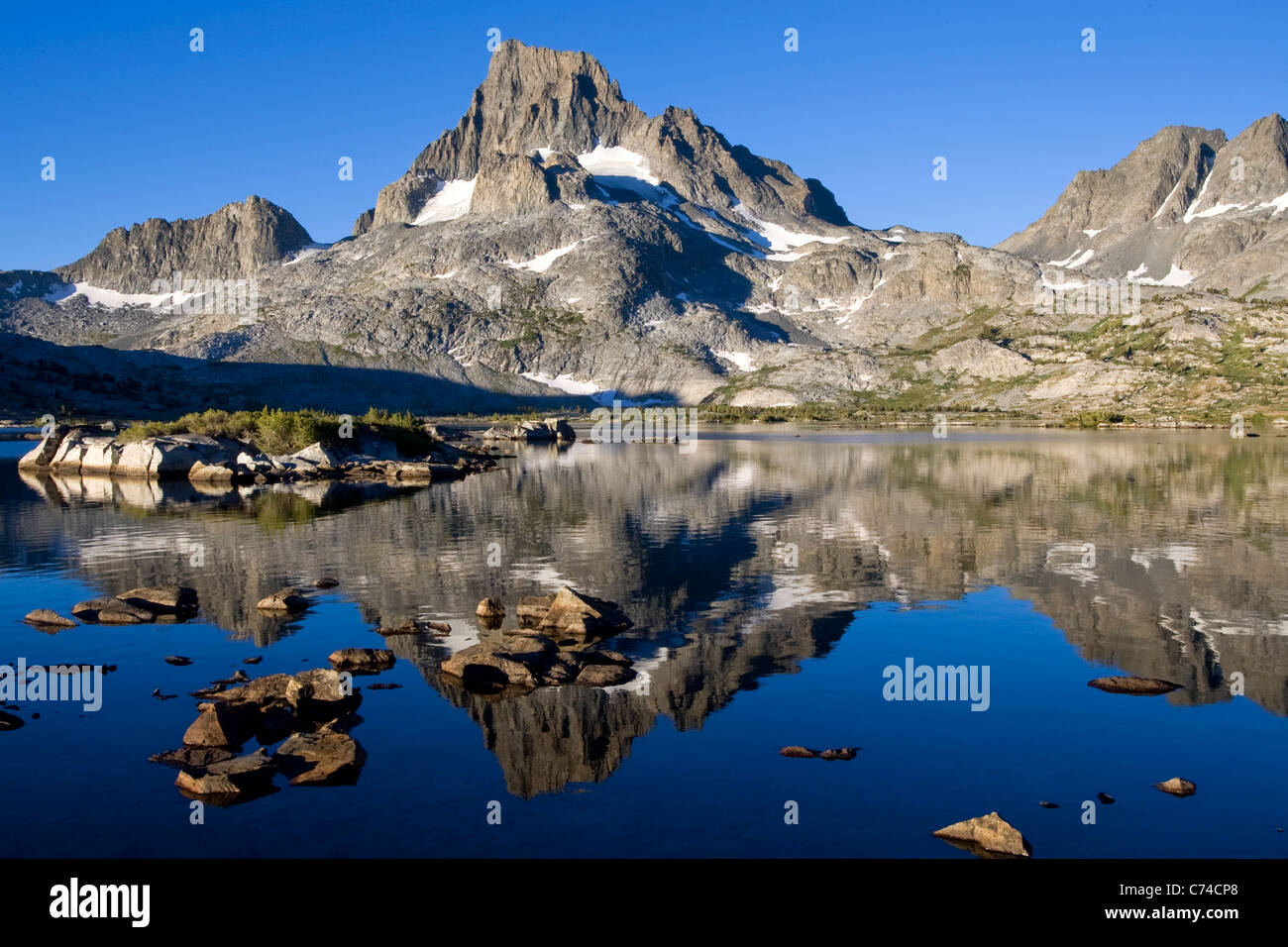 Reflejo de una montaña cubierta de nieve en una Sierra Alta Lake en California. Foto de stock