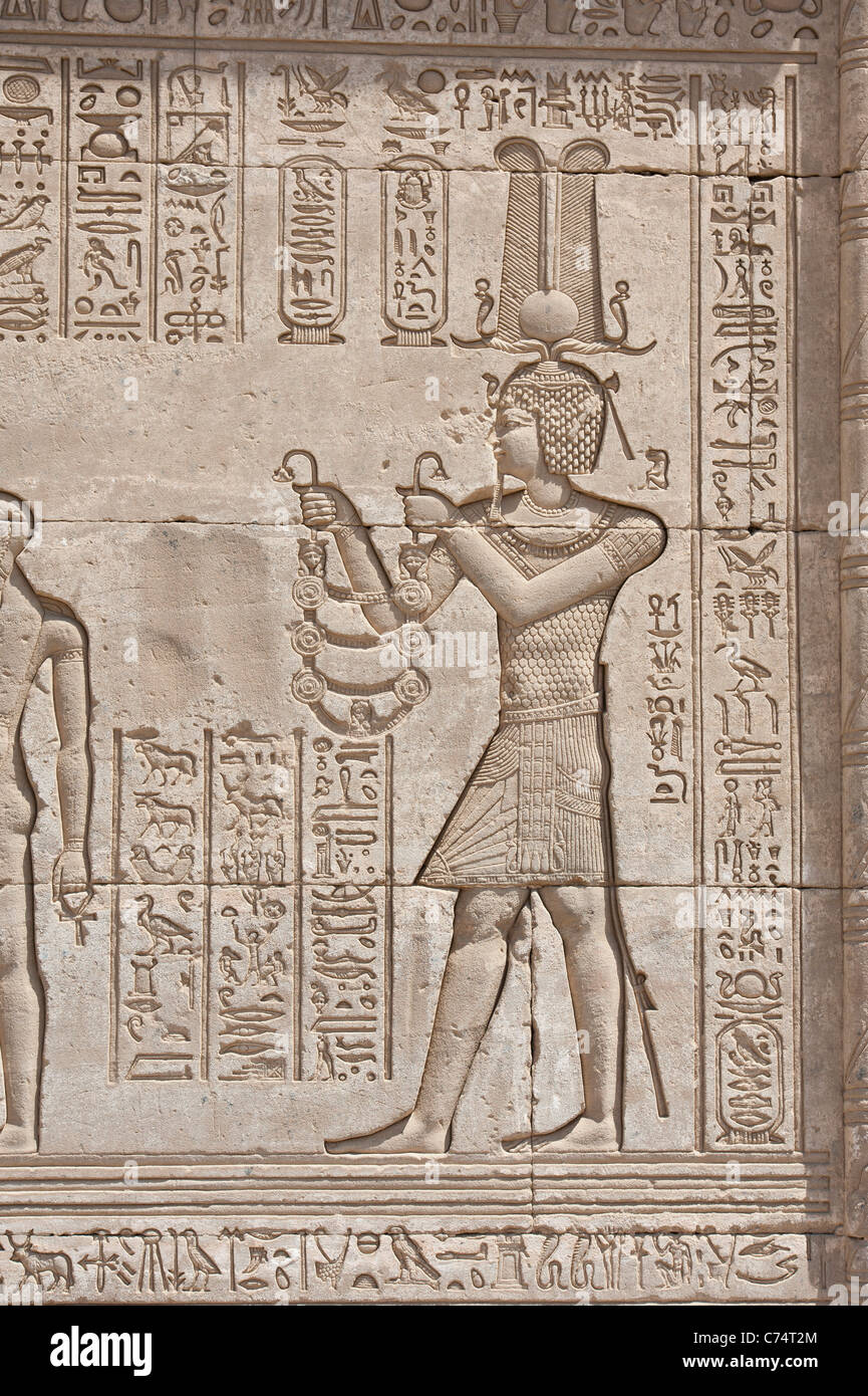 Jeroglíficos tallados en las paredes exteriores de un antiguo templo egipcio Foto de stock
