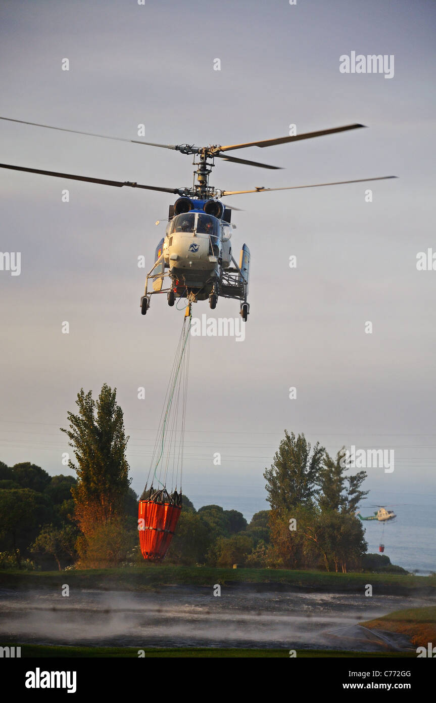 Kamov Ka-32A11BC helicóptero recogiendo agua, Cabopino Golf, Costa del Sol, Málaga, Andalucía, España, Europa Occidental. Foto de stock