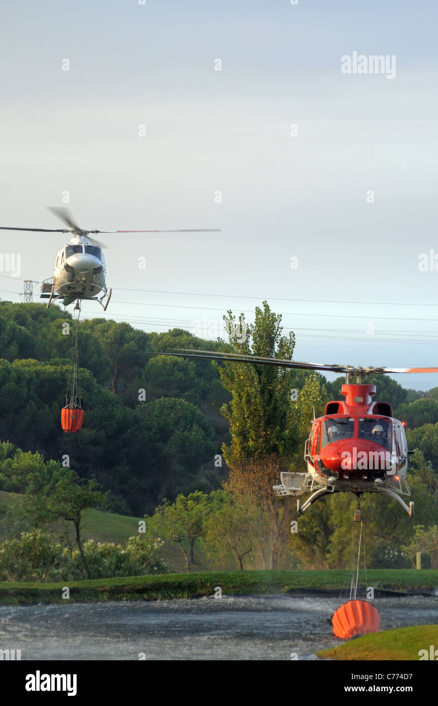 Helicóptero Bell 412 recogiendo agua, Cabopino Golf, Costa del Sol, Málaga, Andalucía, España, Europa Occidental. Foto de stock