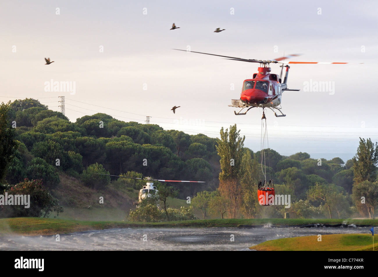 Helicóptero Bell 412 recogiendo agua, Cabopino Golf, Costa del Sol, Málaga, Andalucía, España, Europa Occidental. Foto de stock