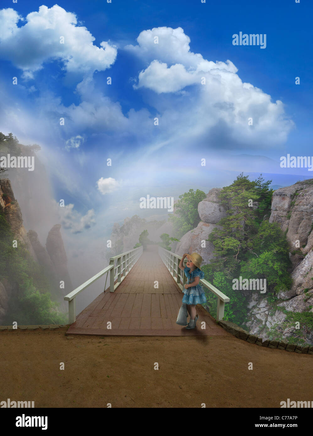 Chica en vestido azul en un puente, vista de la montaña de niebla. Foto de stock
