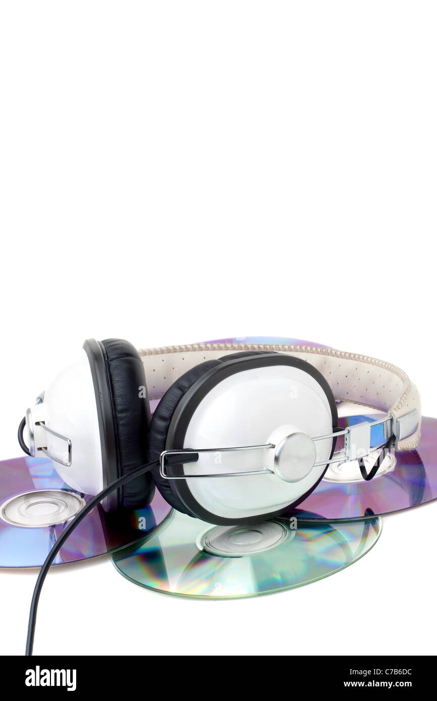 Un juego de auriculares estéreo sobre la parte superior de una pila de discos compactos aislado sobre blanco. Foto de stock