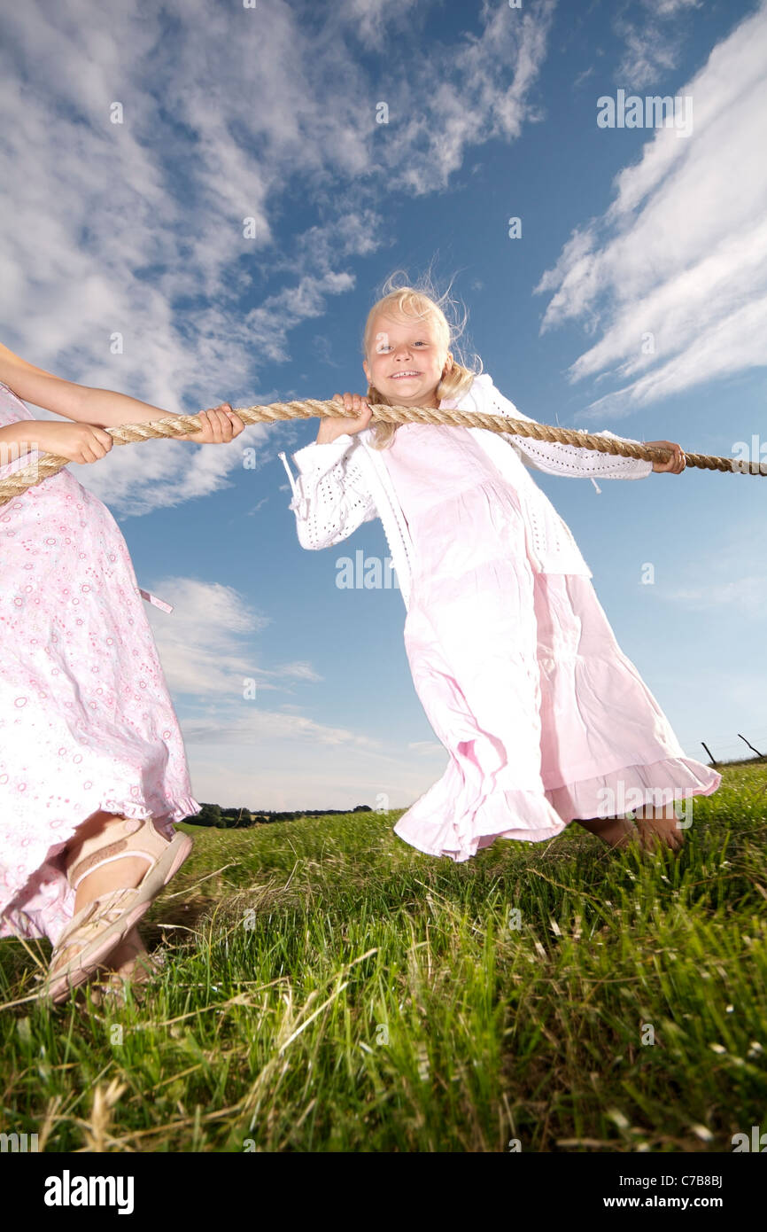Niños jugando tug-of-war en un prado en verano, Eyendorf, Baja Sajonia, Alemania, Europa Foto de stock