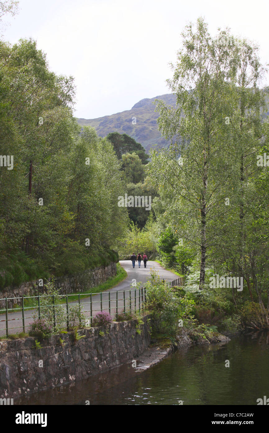 Tres caminantes junto a Loch Katrine en los Trossachs Escocia Foto de stock